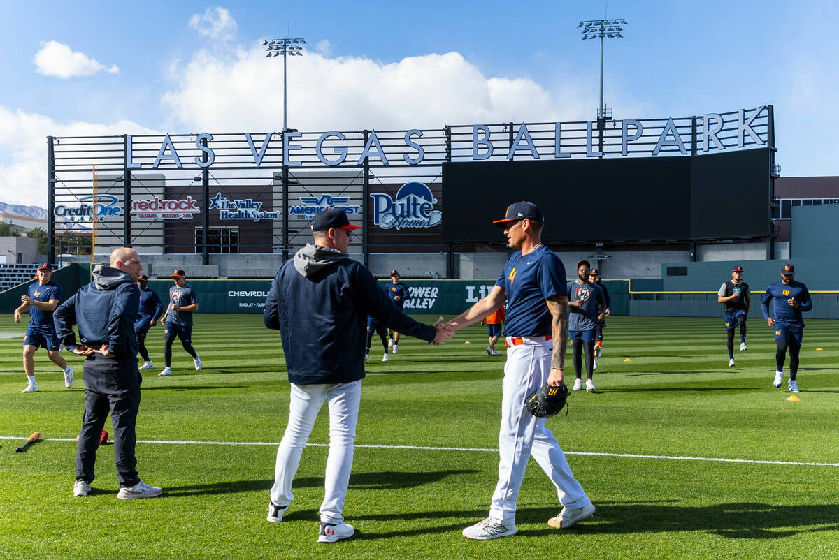 Aviators Manager Fran Riordan, center, greets pitcher Aaron Brooks (38) during practice at the ...
