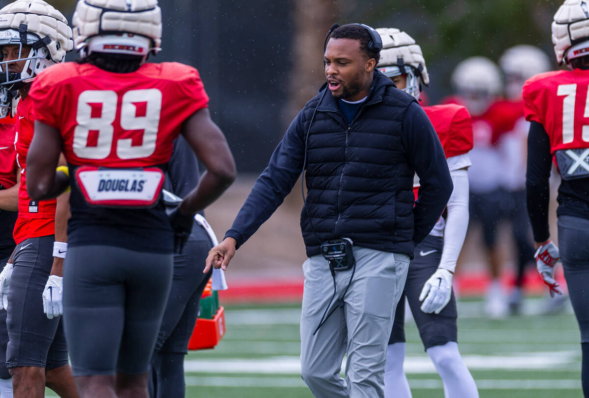 UNLV offensive coordinator Brennan Marion counsels his players while throwing a receiving durin ...