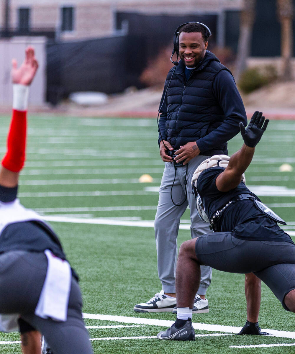 UNLV offensive coordinator Brennan Marion has a conversation with one of his players while stre ...