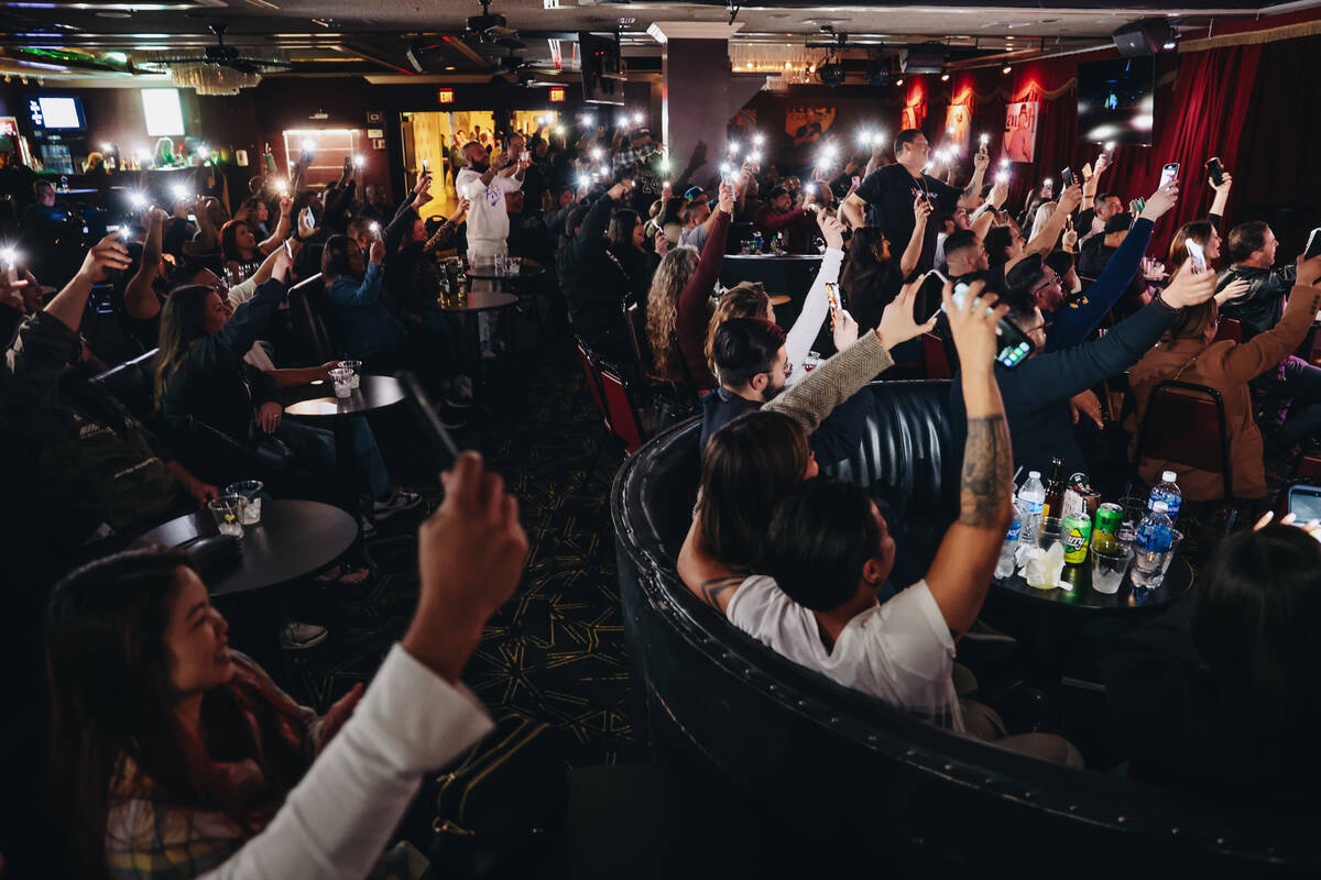 Crowd members wave their phone flashlights in the air during a stand-up by Concrete at the Laug ...