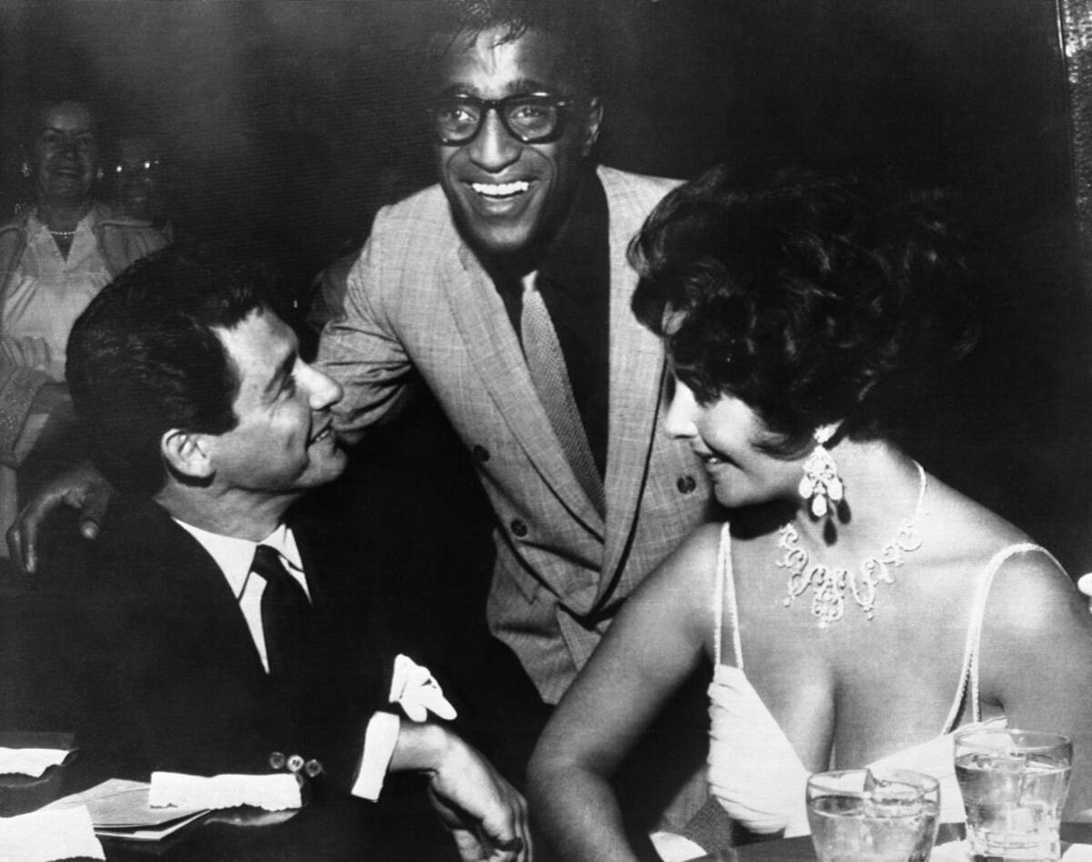 Elizabeth Taylor, right, and Eddie Fisher, left, discuss wedding plans with Sammy Davis Jr. sho ...