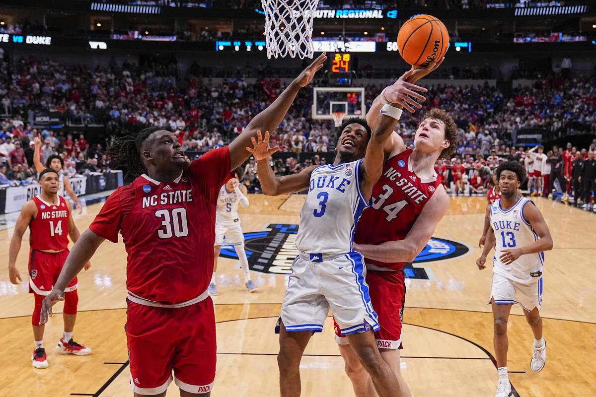 Duke's Jeremy Roach (3) goes up for a shot against North Carolina State's DJ Burns Jr. (30) and ...