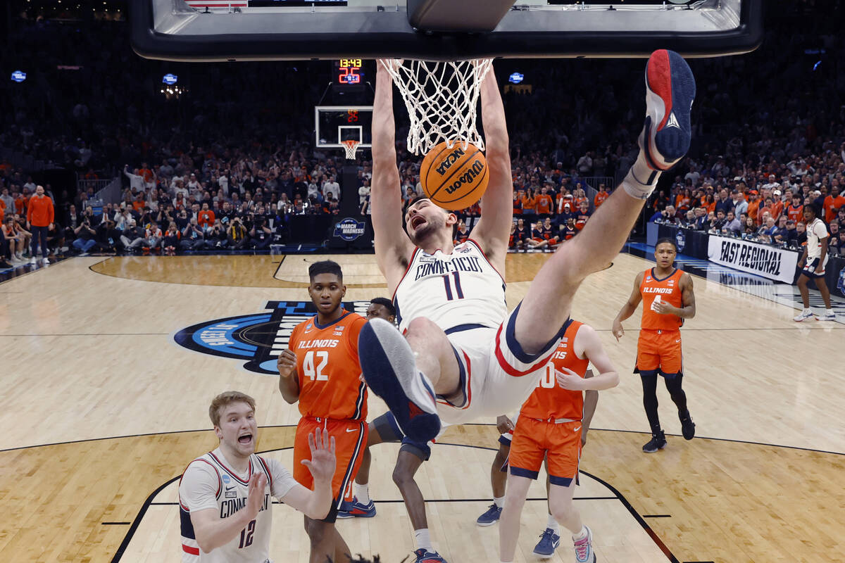 UConn forward Alex Karaban (11) hangs on the rim on his dunk against Illinois during the second ...