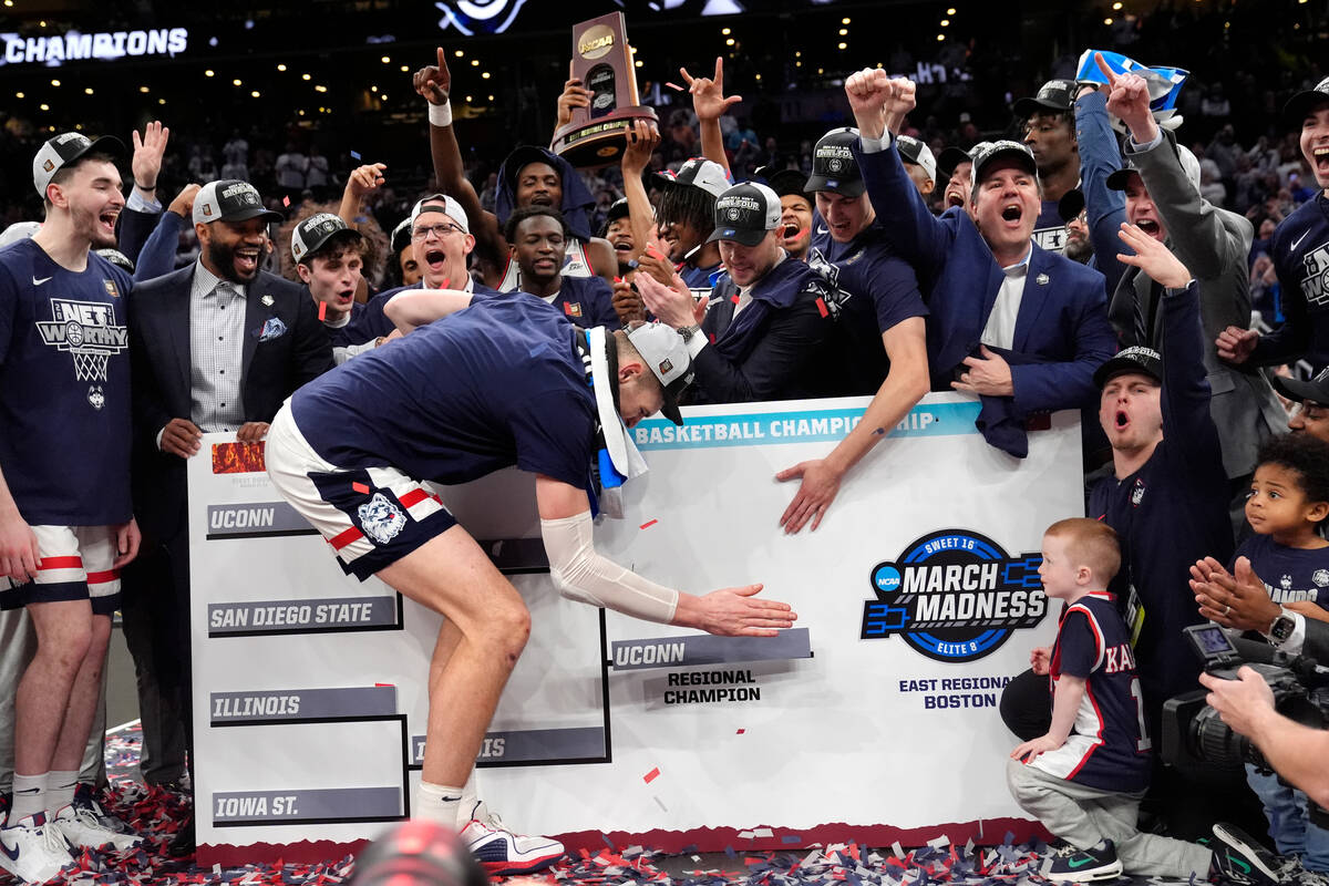 UConn center Donovan Clingan adds his team to the Final Four bracket while celebrating after de ...
