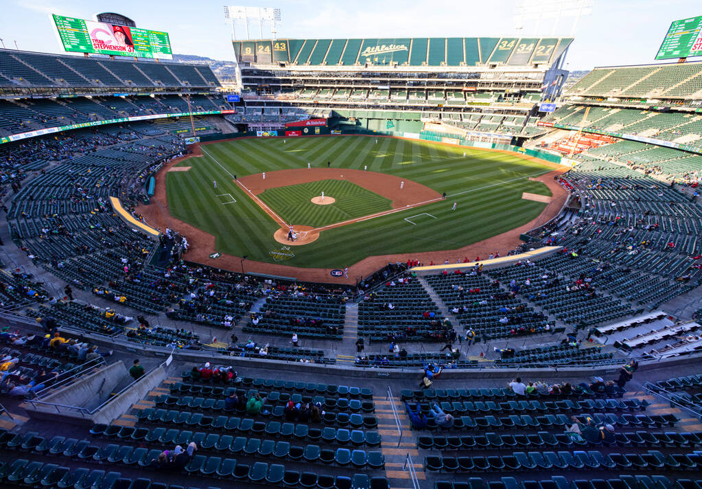 Fans watch a baseball game between the A’s and the Cincinnati Reds at the Oakland Colise ...