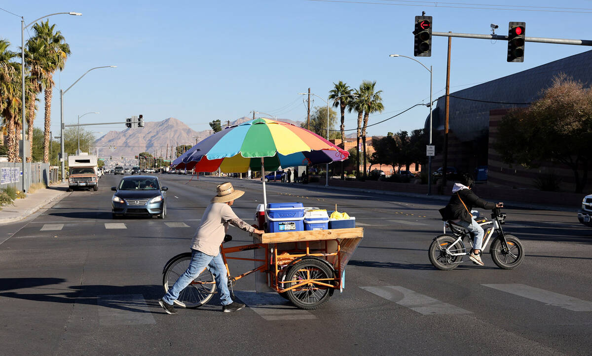 Street vendor Luis Serrano rolls his cart to serve customers in the Historic Westside in Las Ve ...