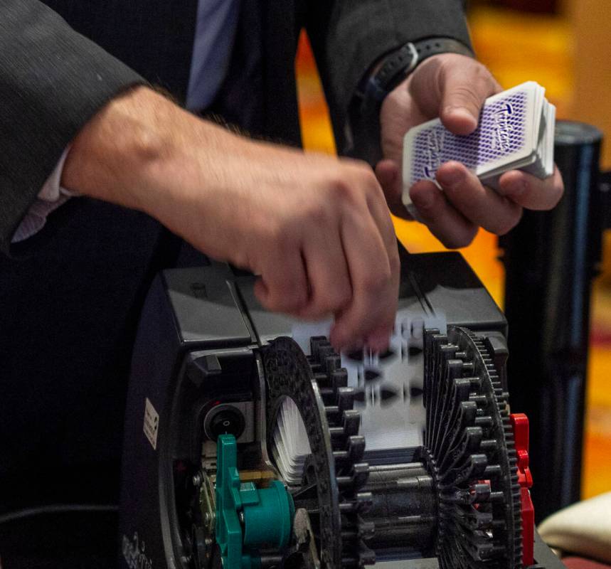 Playing cards are gathered from an automatic shuffling machine as table games are concluded dur ...