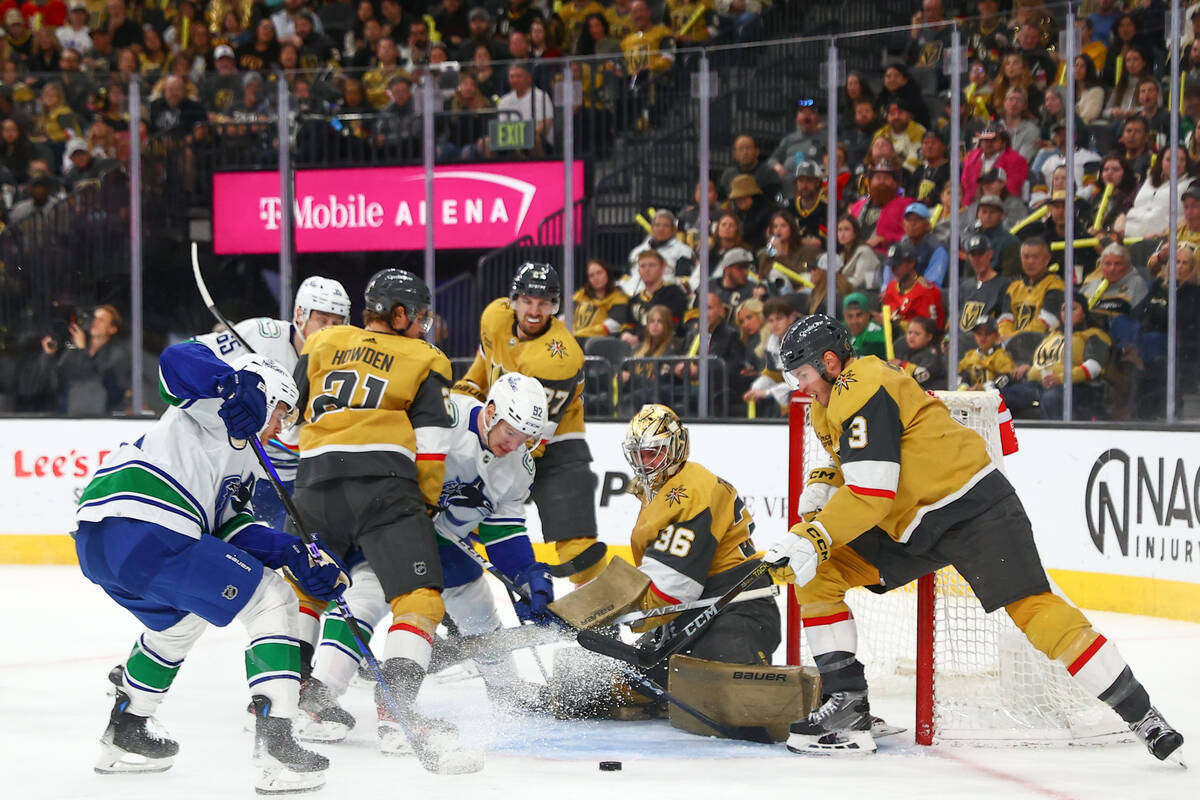 Golden Knights goaltender Logan Thompson (36) prepares to save the puck while Canucks right win ...