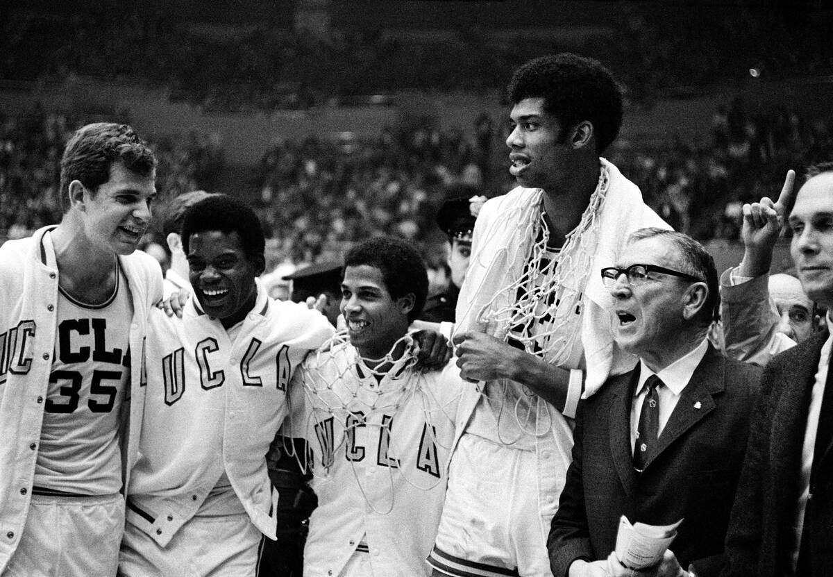 UCLA coach John Wooden, right, wearing eyeglasses, celebrates with his players, from left, Mike ...