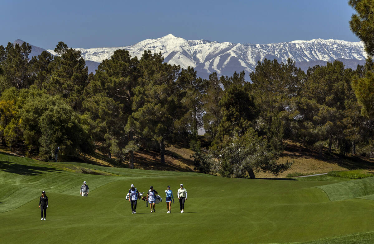 Danielle Kang, left, walks up the 7th fairway with caddies and opponents Maria Fassi and Britta ...