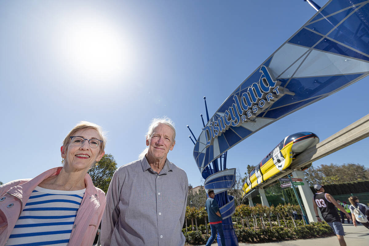 Climate activists Zan Dubin and Paul Scott stand near the entrance to Disneyland as the Monorai ...