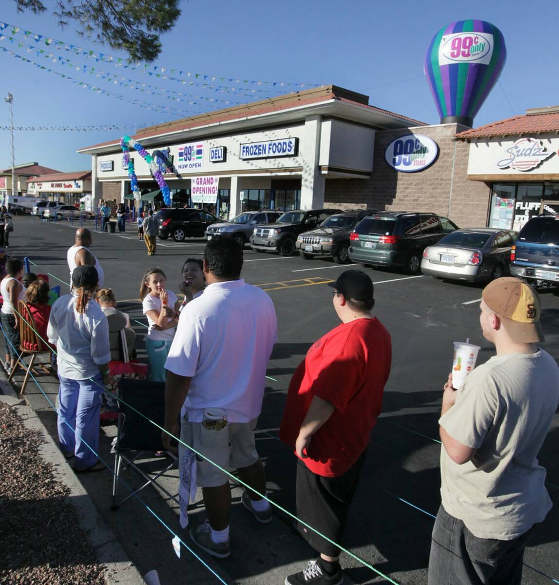 Hundreds of customers line up around the block for the grand opening of the 99 Cents Only store ...