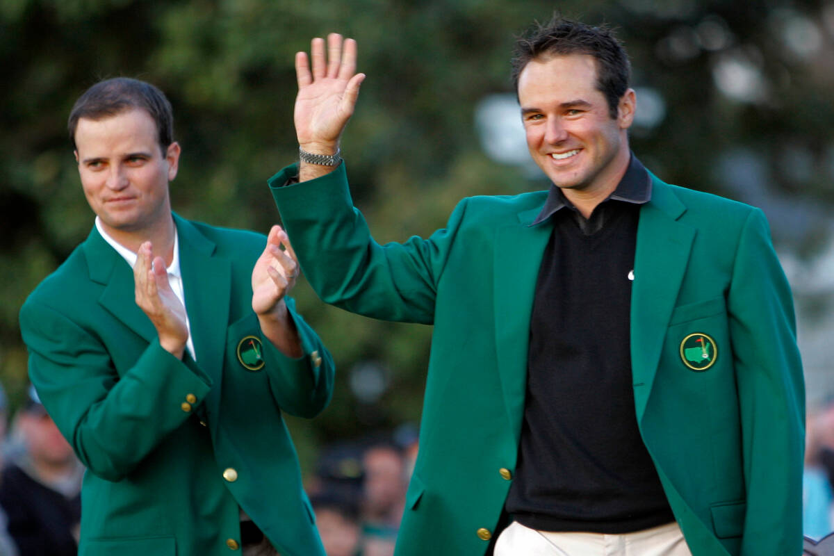 Zach Johnson, left, applauds as Trevor Immelman of South Africa waves to patrons after winning ...