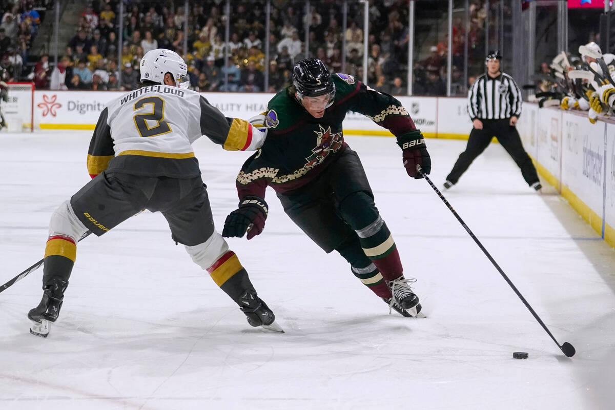 Arizona Coyotes defenseman Michael Kesselring (5) skates around Vegas Golden Knights defenseman ...