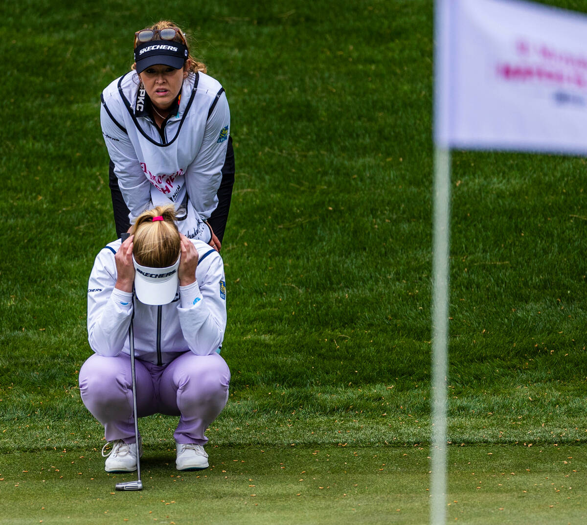 Brooke Henderson is dismayed after dropping two strokes as her caddie Brittany Henderson looks ...
