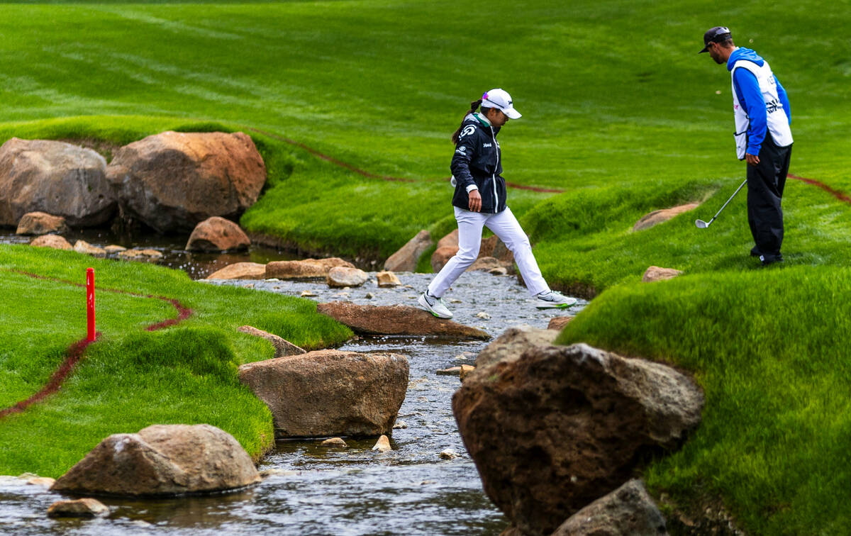 Mi Hyang Lee crosses the creek as she and caddie search for her ball at hole #15 during the thi ...