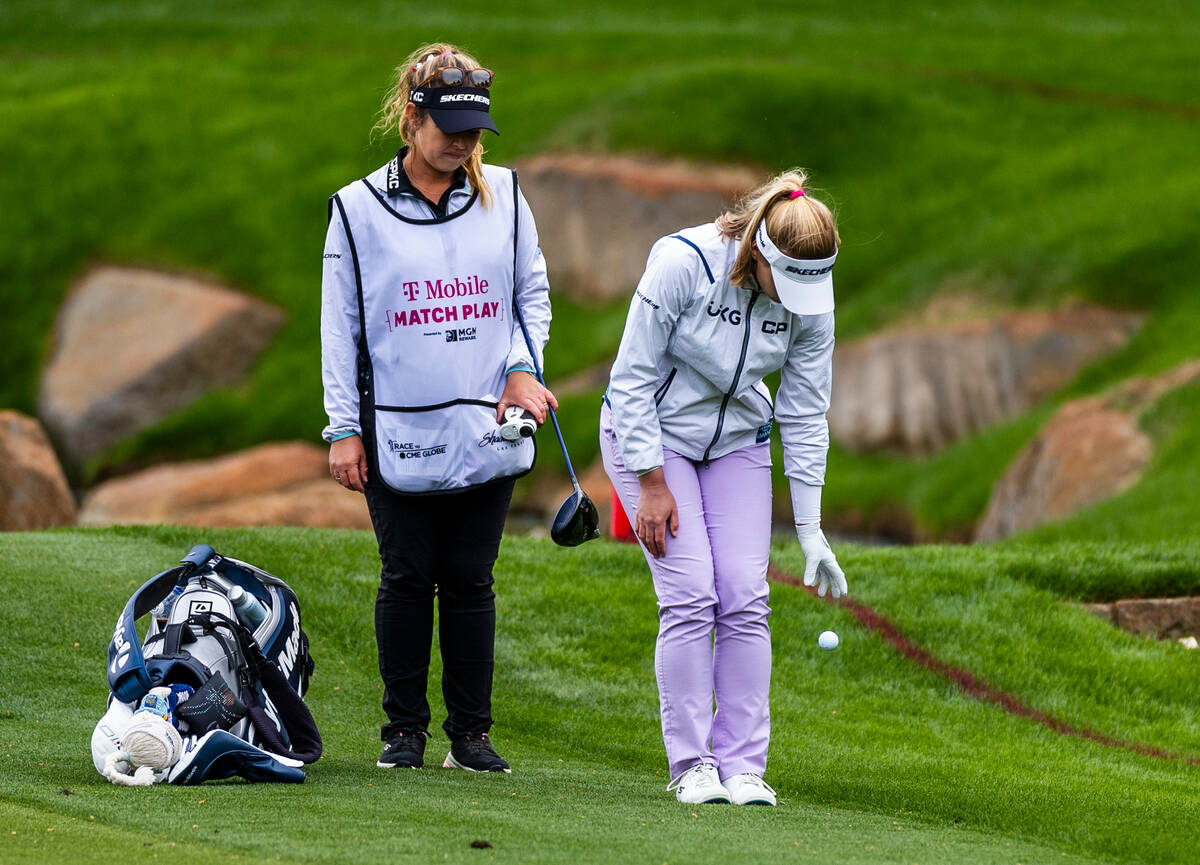 Brooke Henderson drops a new ball after landing in the water as her caddie Brittany Henderson w ...