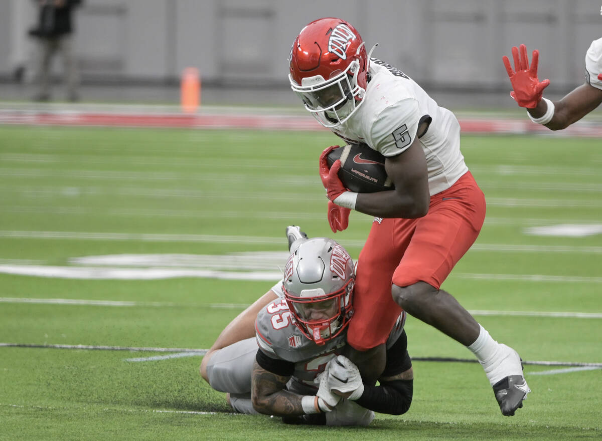 UNLV defensive back Anthony Costanzo tackles running back Greg Burrell during UNLV football&#x2 ...