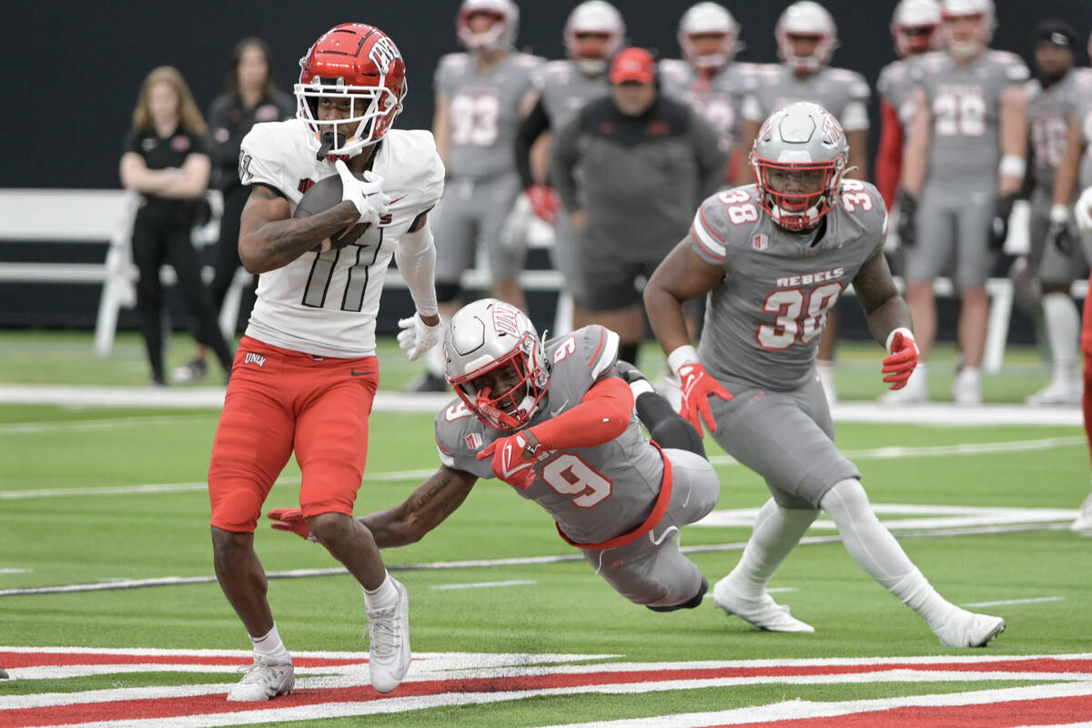 UNLV wide receiver Ricky White III gets past defensive back Jeff Elad during UNLV football&#x20 ...