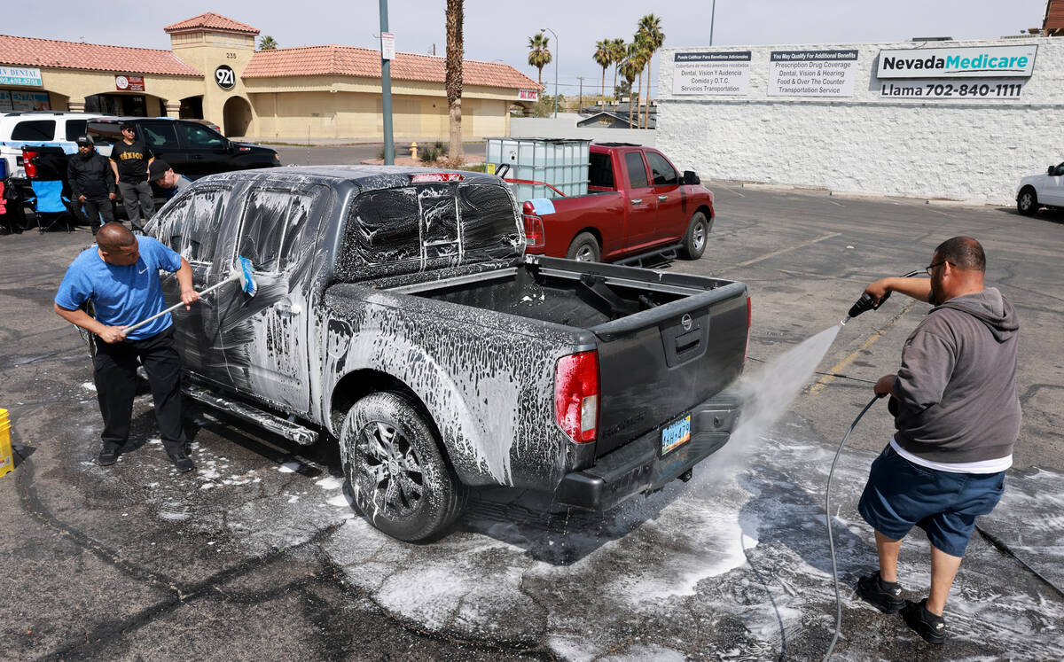 Juan Sandoval, left, and Jose Tejeda wash a truck during a fundraiser for the family of Raul Ca ...