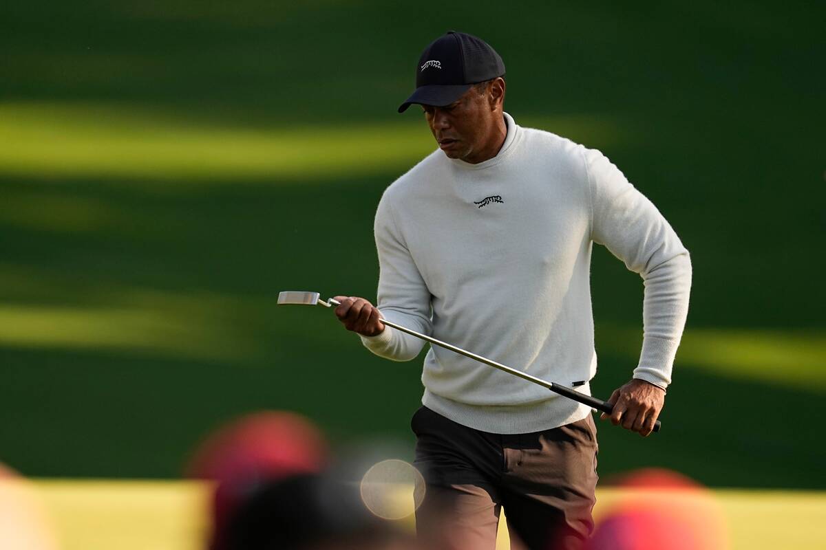 Tiger Woods looks at his putter on the 10th hole during a practice round in preparation for the ...