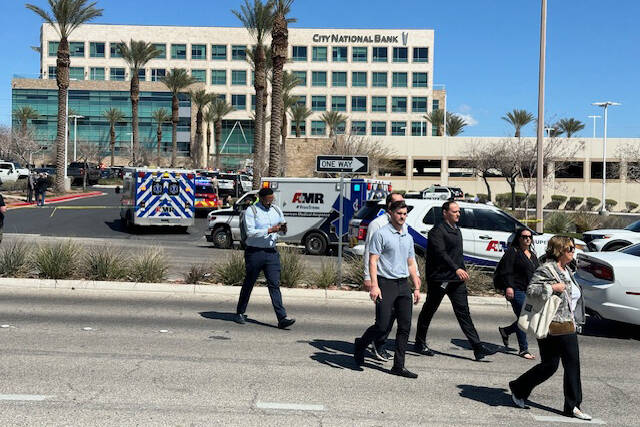 Employees are evacuated from a business on Charleston Boulevard as police investigate a shootin ...