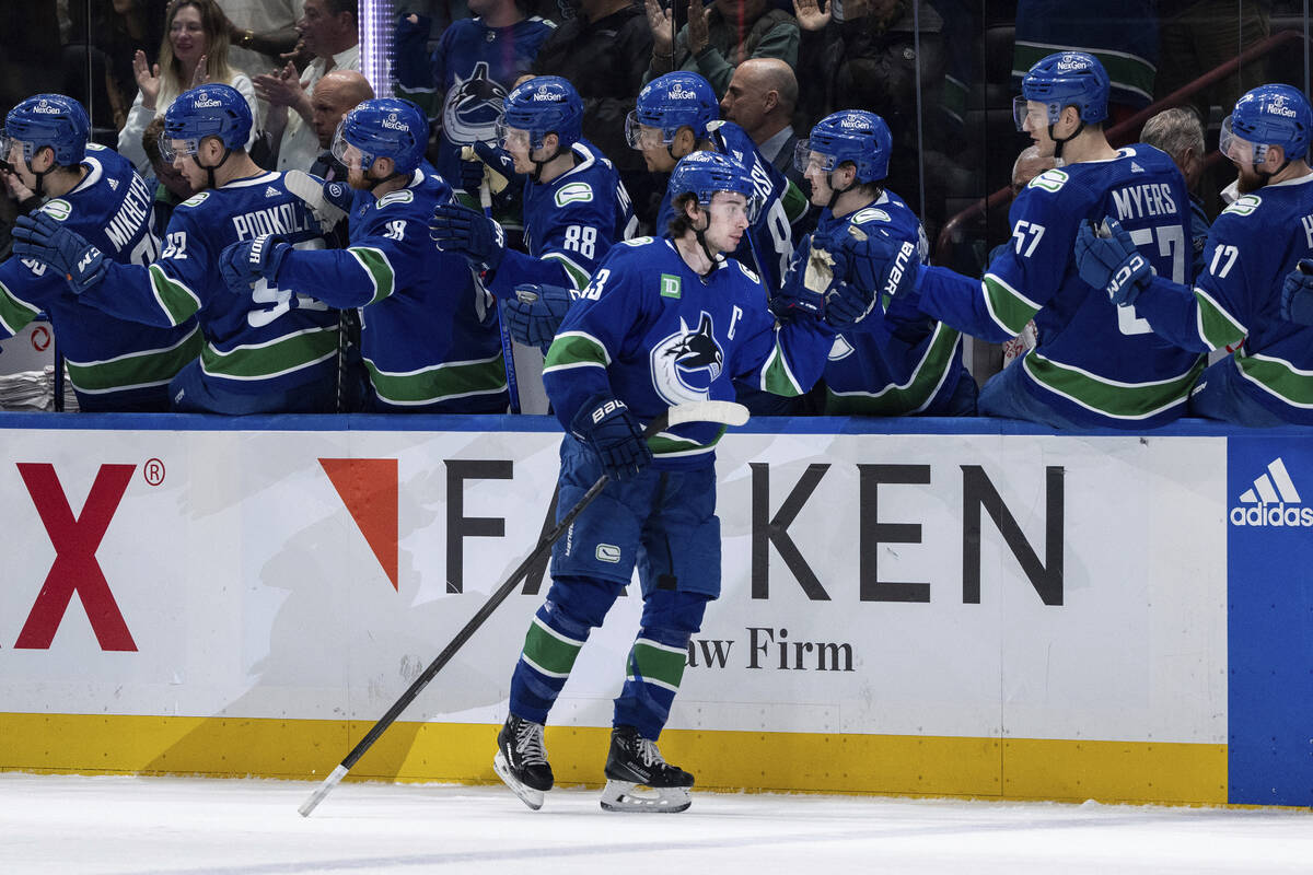 Vancouver Canucks' Quinn Hughes (43) celebrates with his teammates after his goal against the V ...