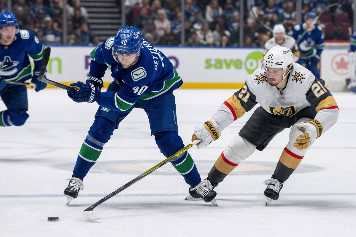 Vancouver Canucks' Elias Pettersson (40) and Vegas Golden Knights' Brett Howden (21) vie for th ...