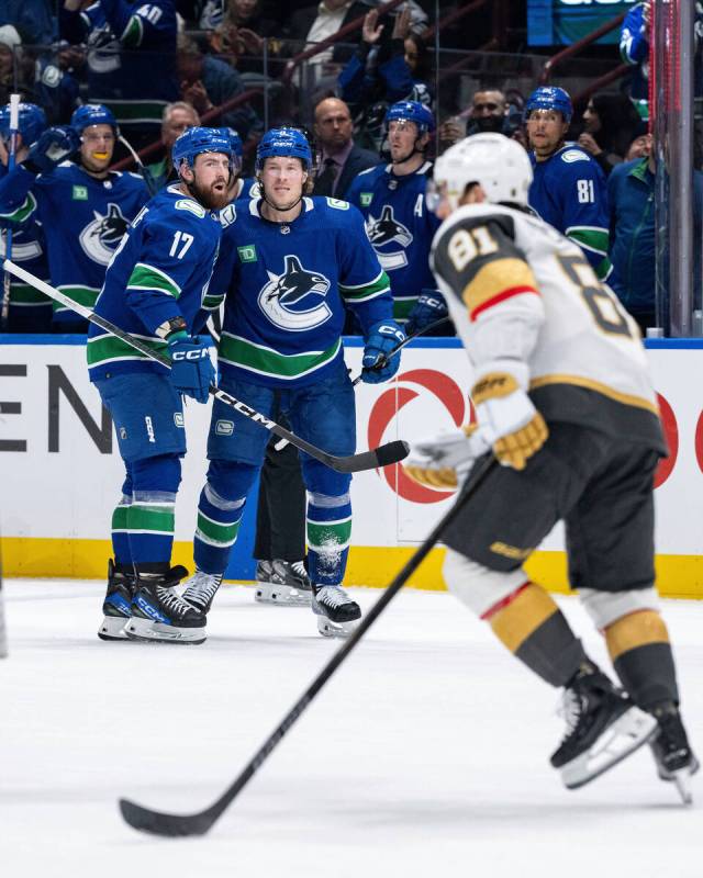 Vancouver Canucks' Filip Hronek (17) celebrates with Brock Boeser (6) after Boeser's goal as Ve ...