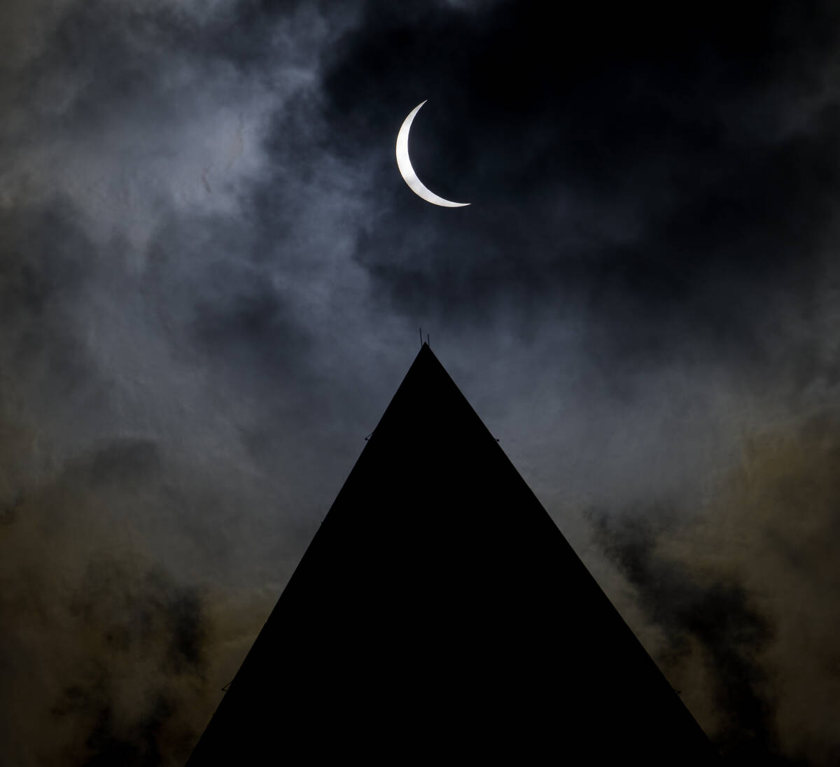 The moon is seen passing in front of the sun with the top of the Washington Monument in silhoue ...