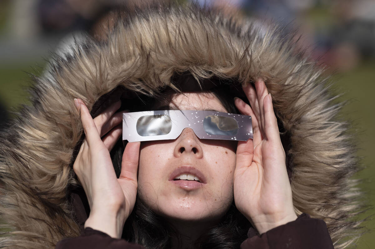 Virginia Salcido wears special glasses to watch a solar eclipse from Griffith Observatory on Mo ...