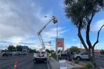 Crews fix wiring on a street light at the intersection of Lamb and Charleston boulevards on Mon ...