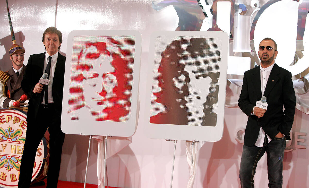 Former members of The Beatles Paul McCartney, left, and Ringo Starr stand next to portraits of ...