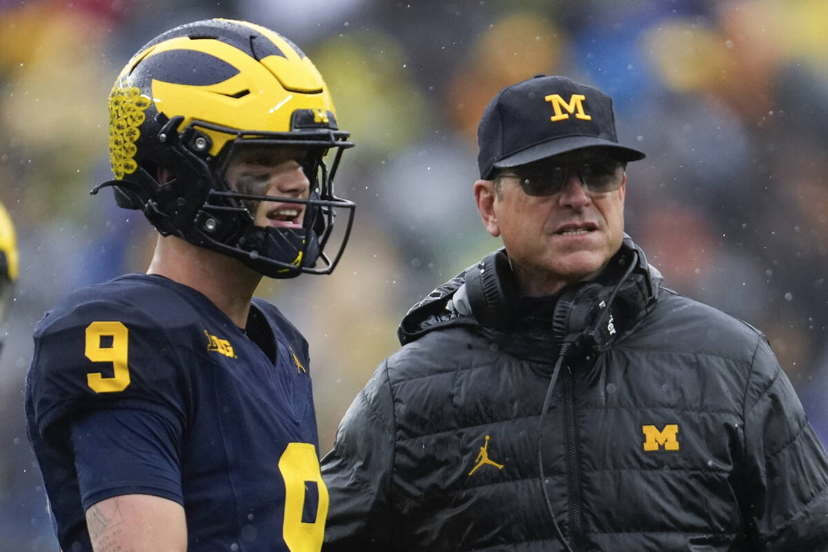 Michigan quarterback J.J. McCarthy (9) and head coach Jim Harbaugh talk in the second half of a ...