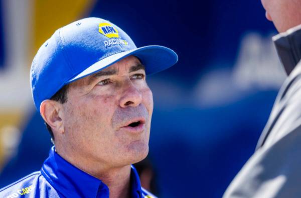 Funny Car driver Ron Capps talks to a friend in the pits during Day 2 of NHRA Nationals at the ...