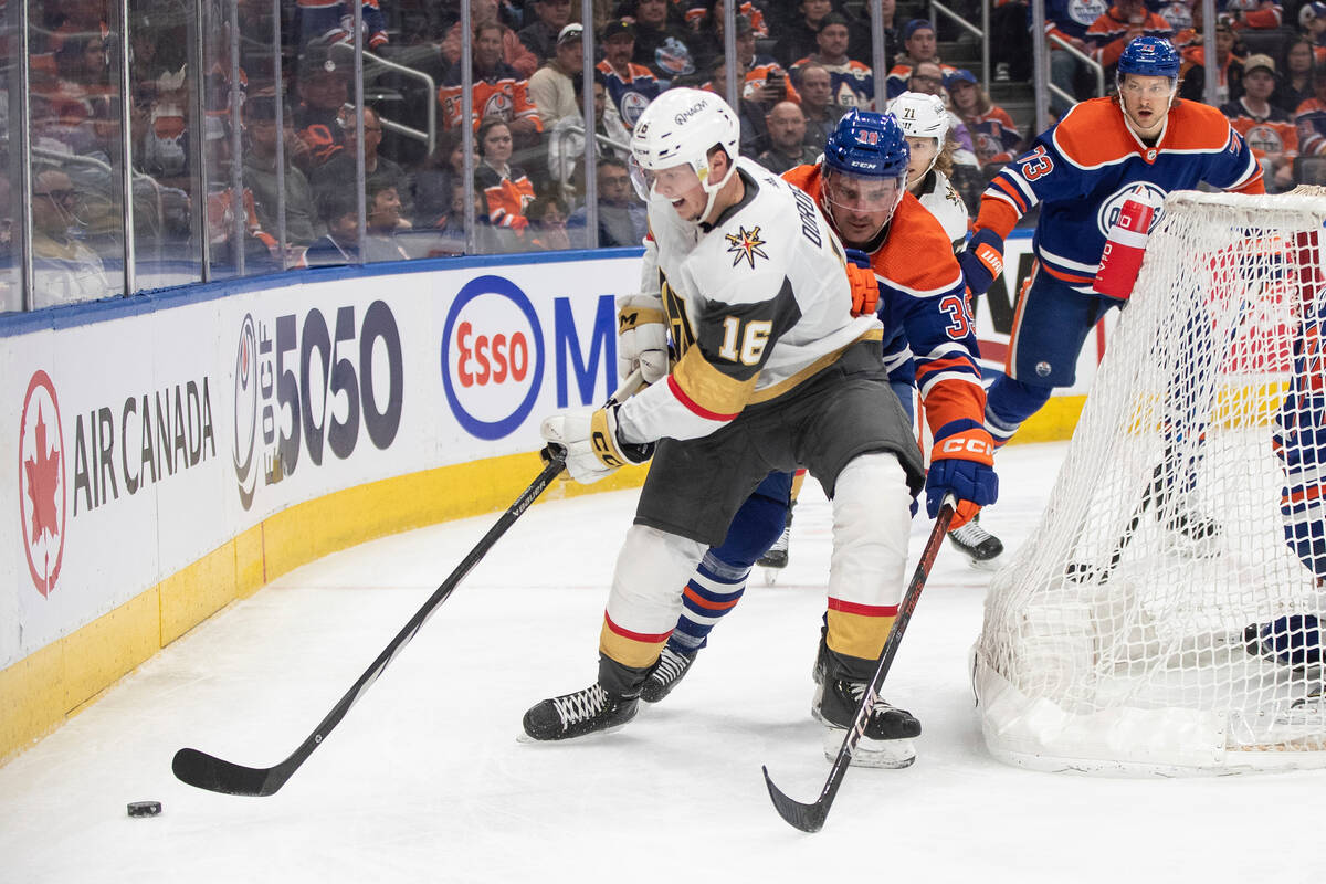 Vegas Golden Knights' Pavel Dorofeyev (16) and Edmonton Oilers' Sam Carrick (39) battle for the ...