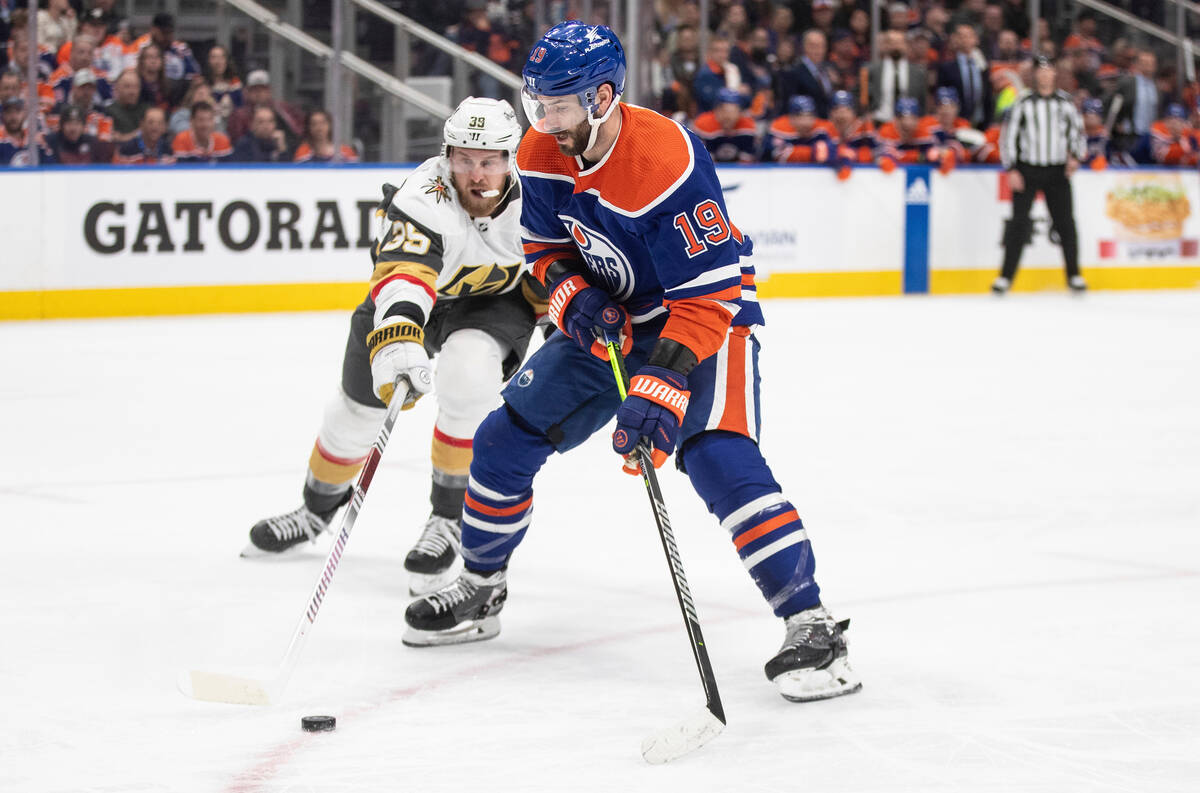 Vegas Golden Knights' Anthony Mantha (39) and Edmonton Oilers' Adam Henrique (19) battle for th ...