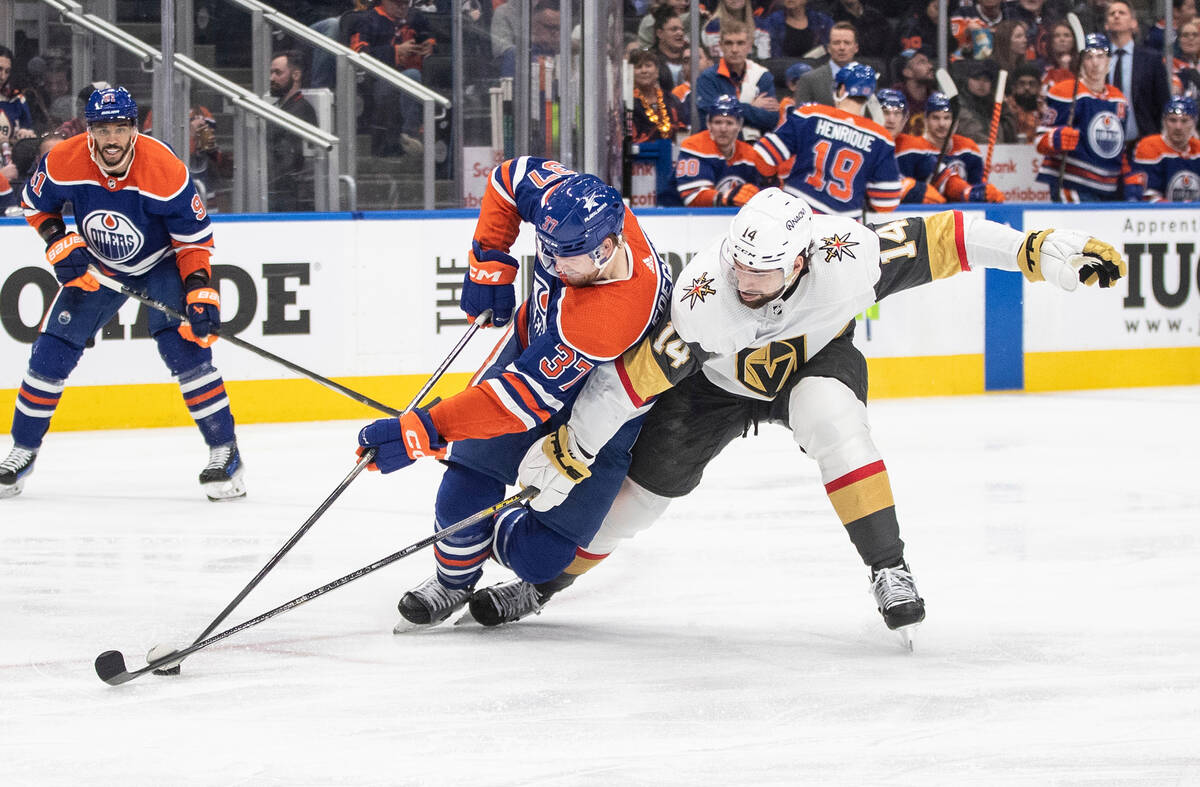 Vegas Golden Knights' Nicolas Hague (14) and Edmonton Oilers' Warren Foegele (37) battle for th ...