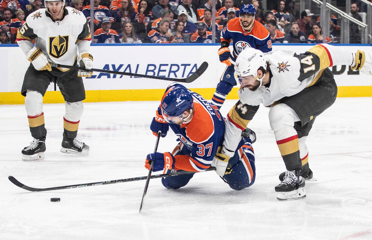 Vegas Golden Knights' Nicolas Hague (14) and Edmonton Oilers' Warren Foegele (37) battle for th ...