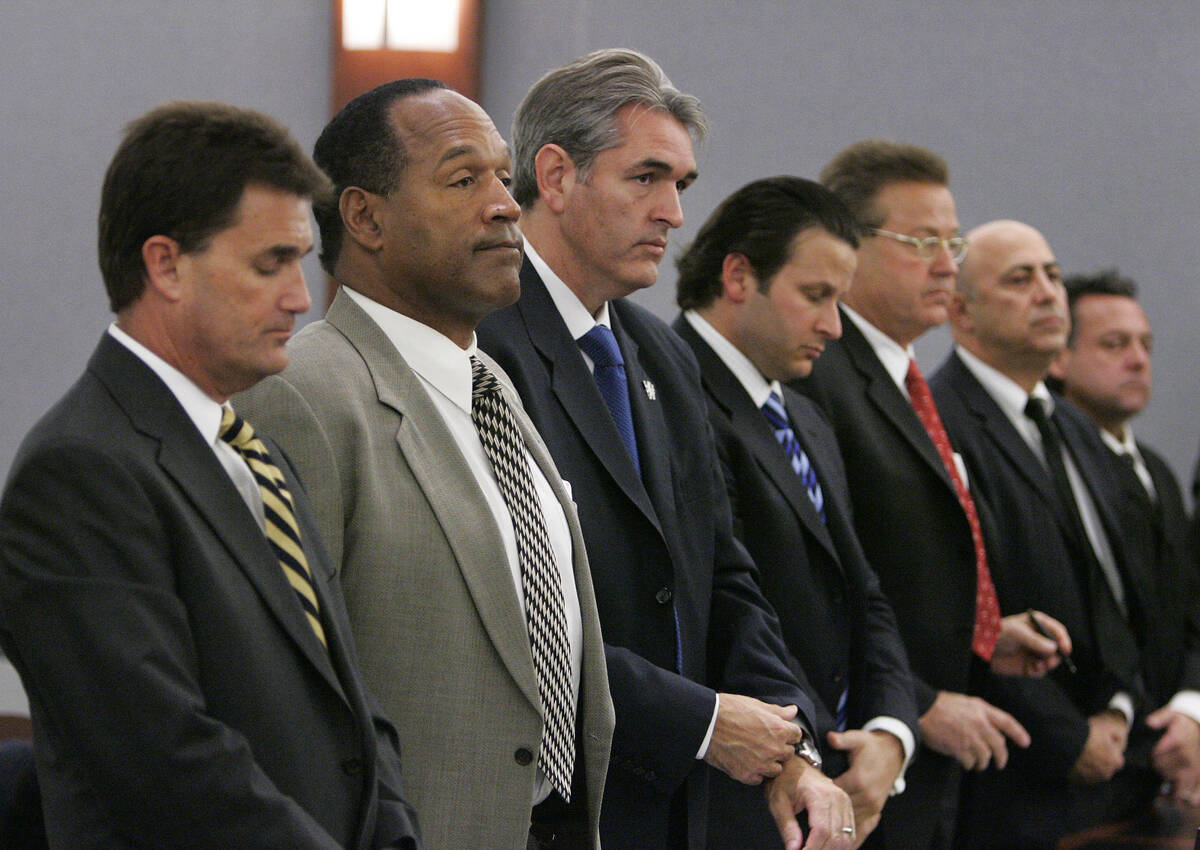 Former NFL great O.J. Simpson, second from left, stands in court flanked by his attorneys Yale ...