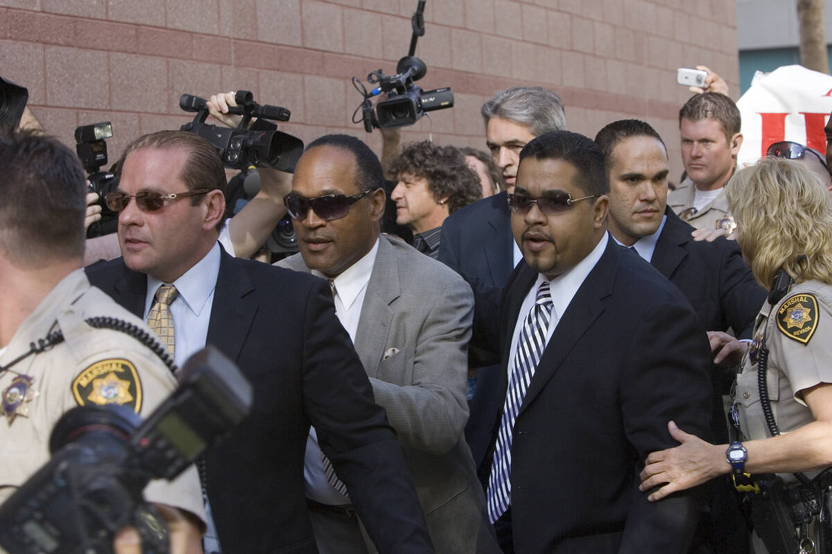 Former NFL player O.J. Simpson, arrives at the Regional Justice Center surrounded by Metro offi ...