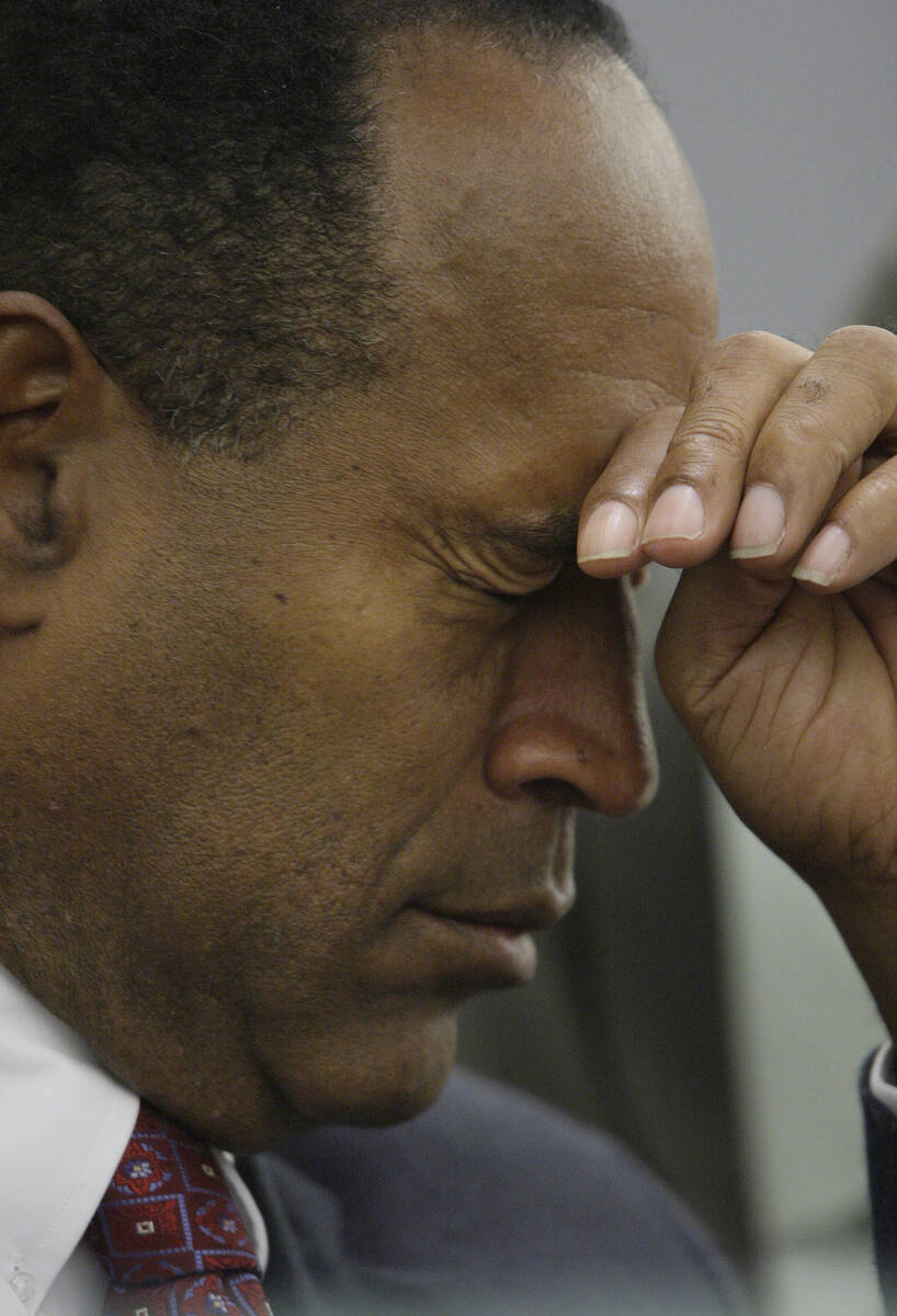 Former NFL player O.J. Simpson rubs his face as he sits in court at the Clark County Regional J ...