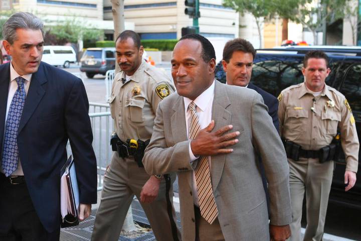 Escorted by court marshals, O.J. Simpson, center, is accompanied by his attorneys Gabriel Grass ...