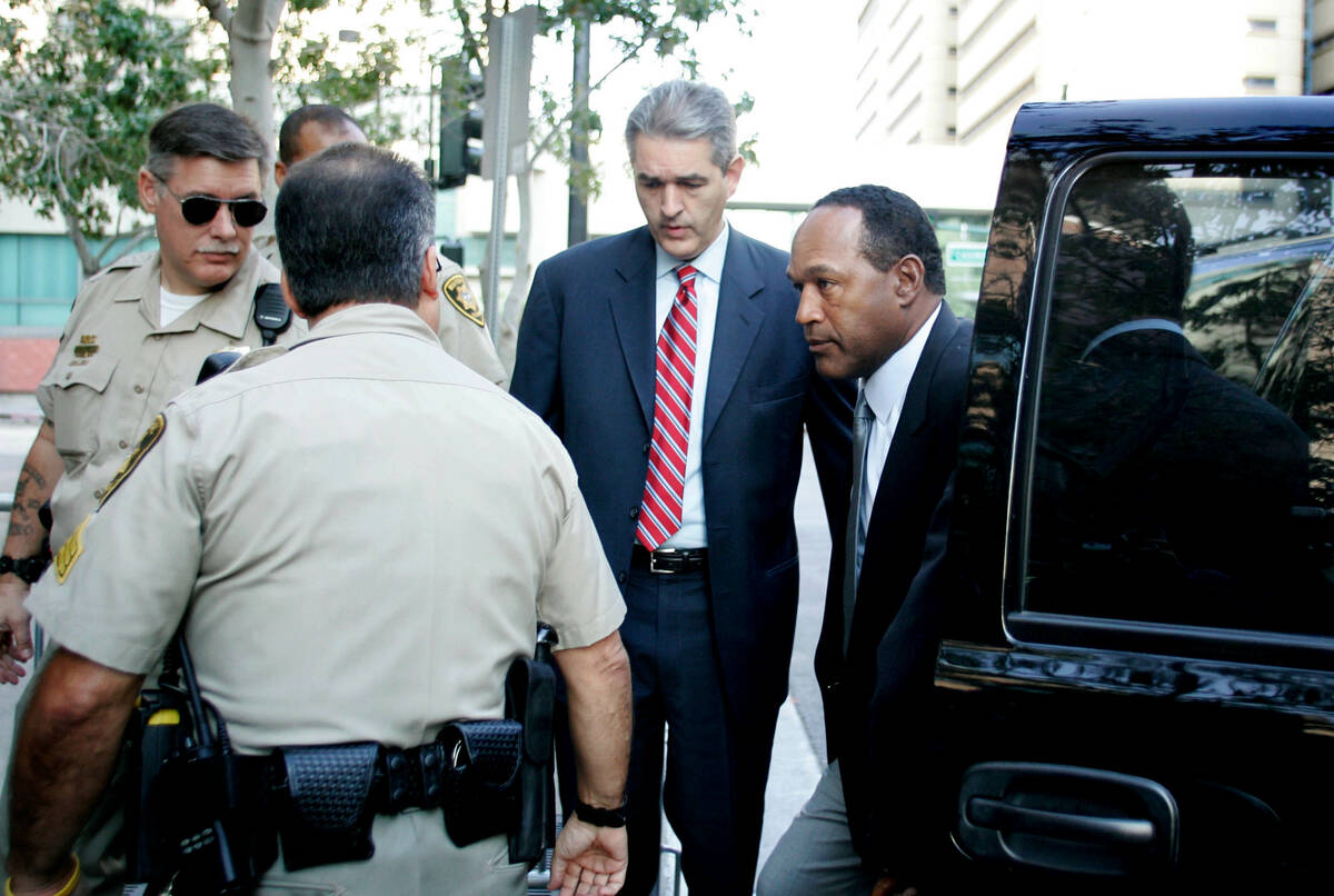 Defendant O.J. Simpson, right, accompanied by his attorney, Gabriel Grasso, is surrounded by me ...