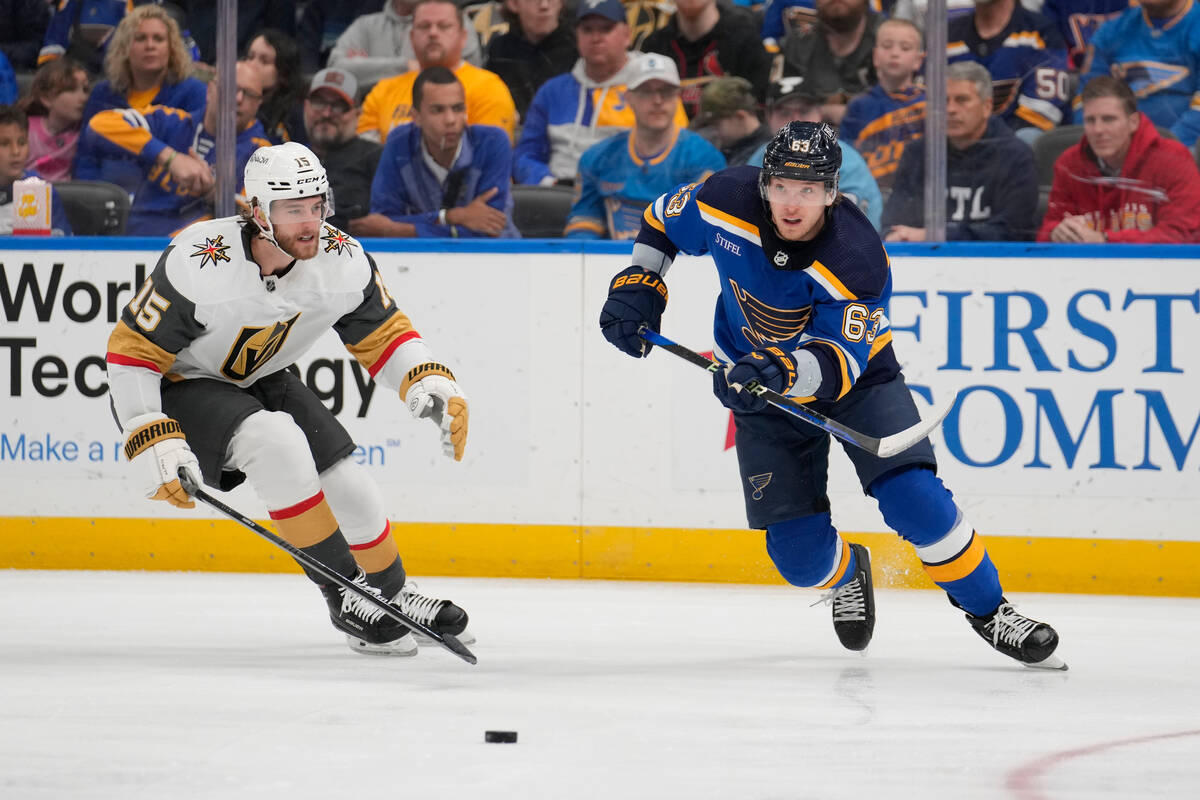 St. Louis Blues' Jake Neighbours (63) passes as Vegas Golden Knights' Noah Hanifin (15) watches ...