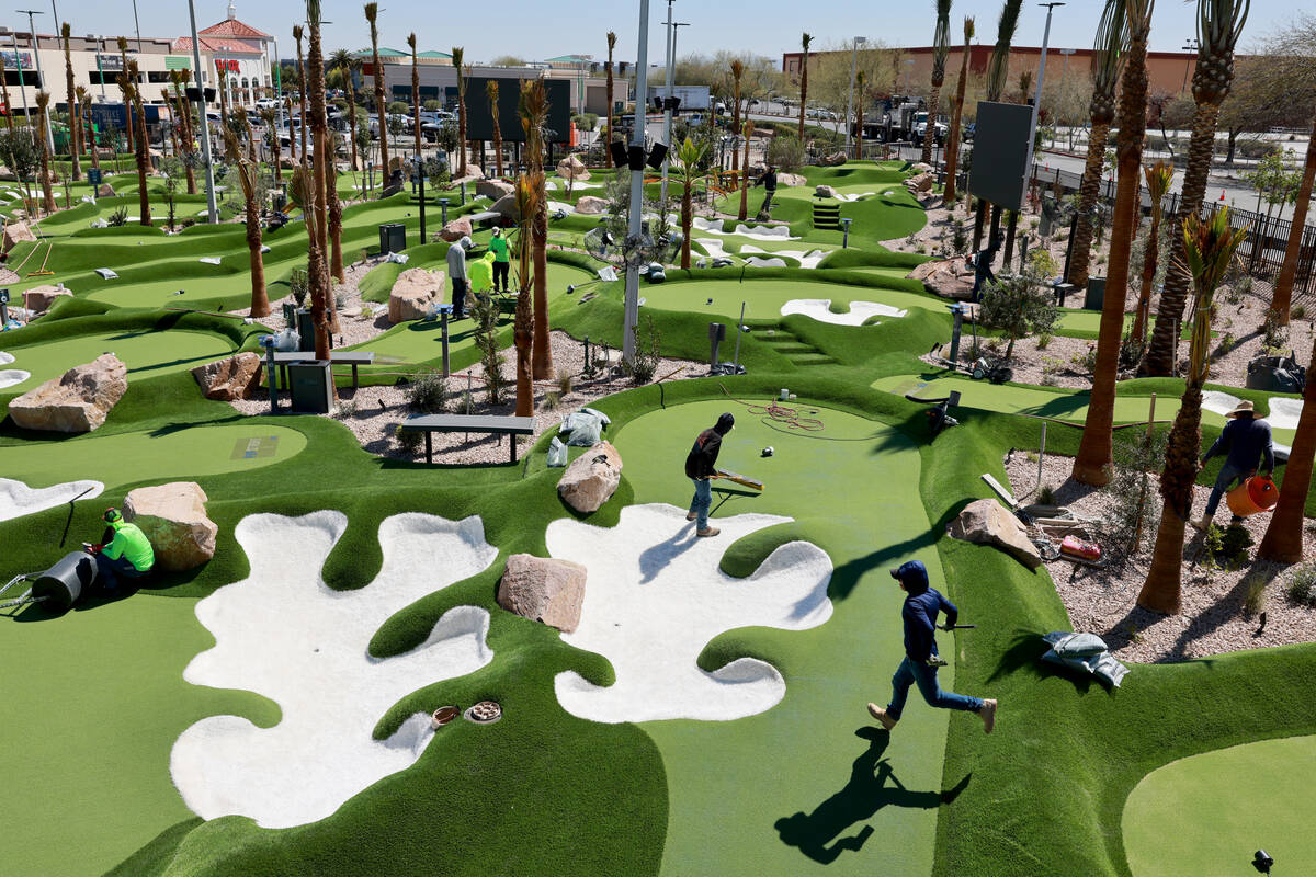 Workers put the finishing touches PopStroke mini-golf and entertainment facility at Town Square ...