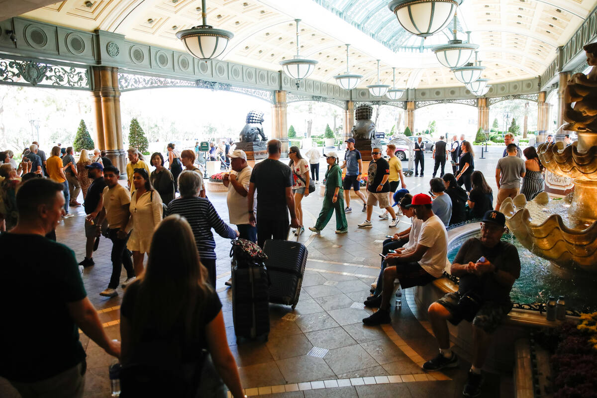 Bellagio guests walk outside of the casino during technological issues at MGM Resorts Internati ...