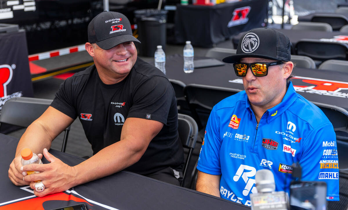 Funny Car racer Matt Hagan laughs as he and Top Fuel racer Tony Stewart talk with the media in ...
