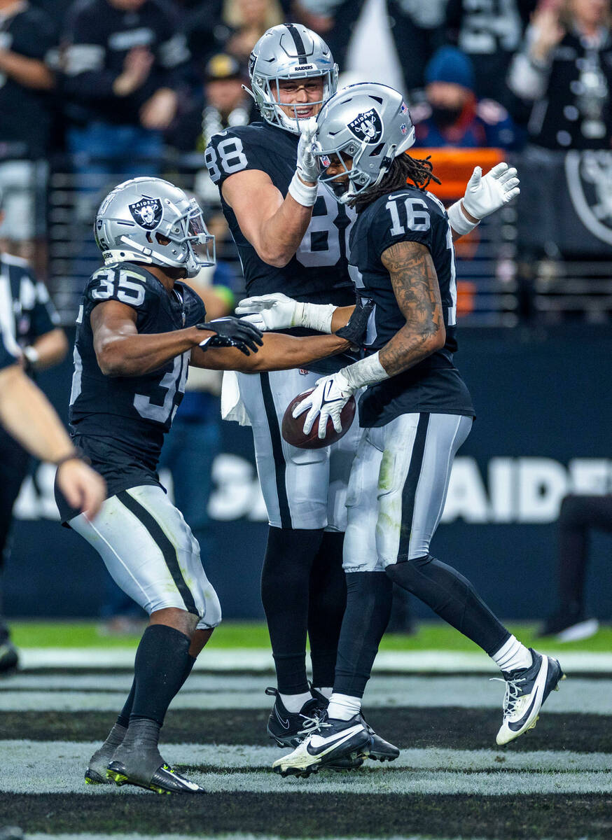 Raiders wide receiver Jakobi Meyers (16) is congratulated by tight end Zach Gentry (88) and run ...