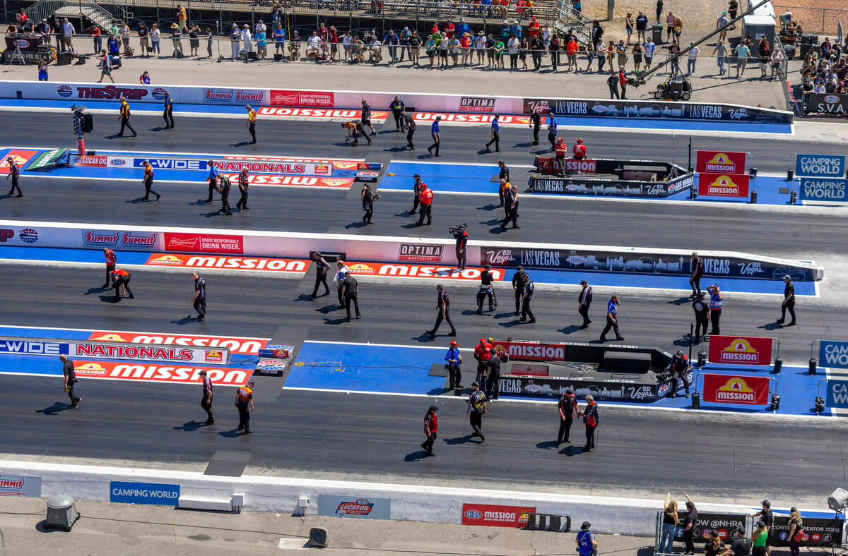 Track and safety personnel check the starting lane for foreign objects during Day 2 of NHRA 4-W ...